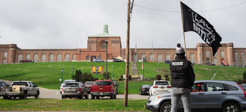 A protester waves a "Black Lives Matter" flag at Elmira Correctional Facility