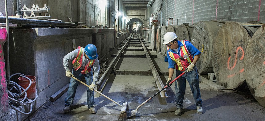 Construction workers sweep at the second avenue subway line