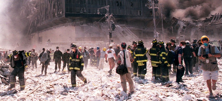 New York City firefighters and journalists stand near the area known as Ground Zero after the collapse of the Twin Towers.