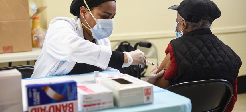 A woman gets a vaccine at the NYCHA vaccine site on Nostrand.