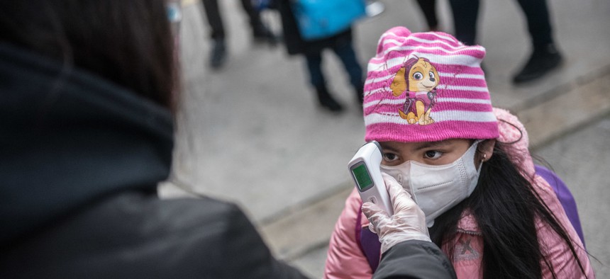 A student getting her temperature checked at P.S. 5 Port Morris in the Bronx on December 7.