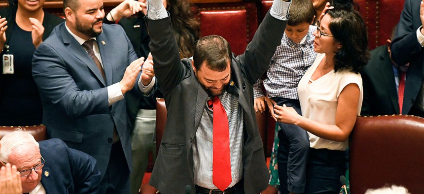 Sen. Luis R. Sepulveda (center) celebrates after the Green Light Bill granting was passed by the state Senate.