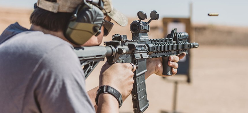 A man shooting an assault rifle.