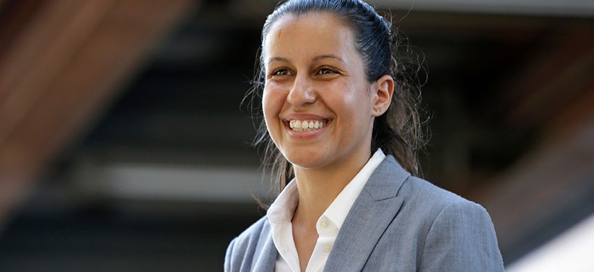 Tiffany Caban smiles while greeting commuters in Queens.