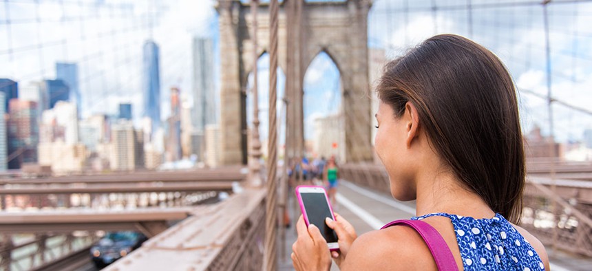 A woman uses her cellphone on the Brooklyn Bridge.
