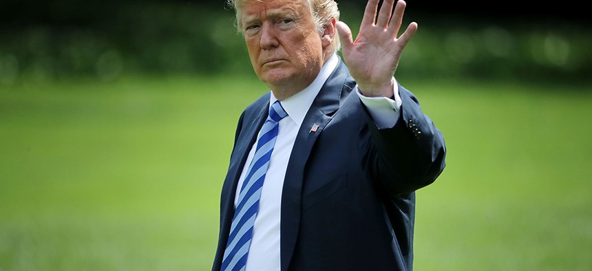 Donald Trump waves to journalists as he walks across the South Lawn.