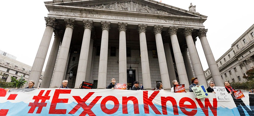 A group of protestors gathered outside of a New York City courthouse at the start of a legal case against Exxon Mobile.