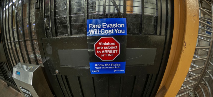 A sign in the subway station in New York warns of the consequences of fare evasion.