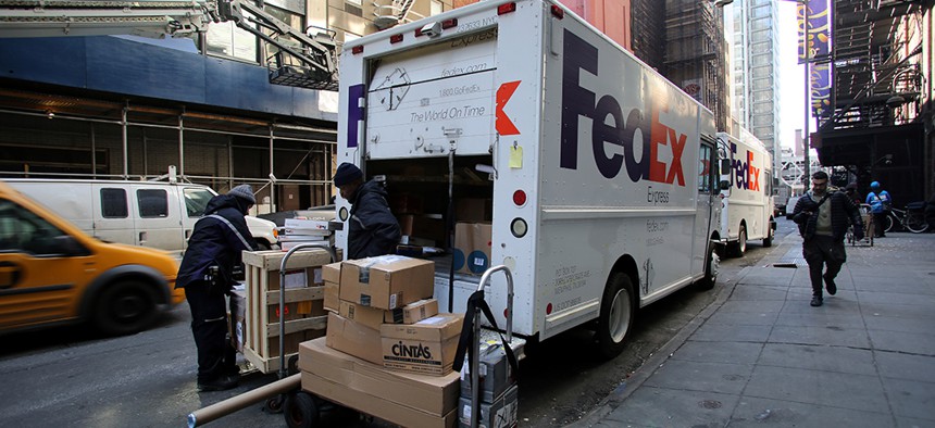 A FedEx driver unloads a delivery truck in midtown Manhattan.