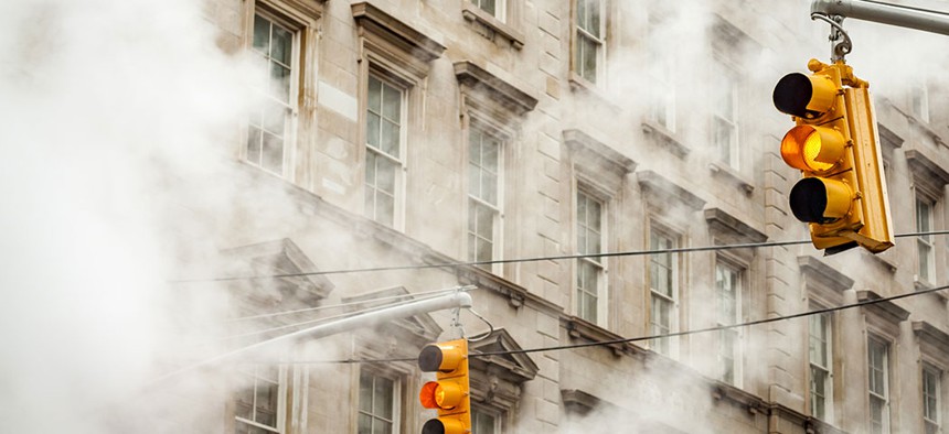 Traffic lights in New York surrounded by steam.