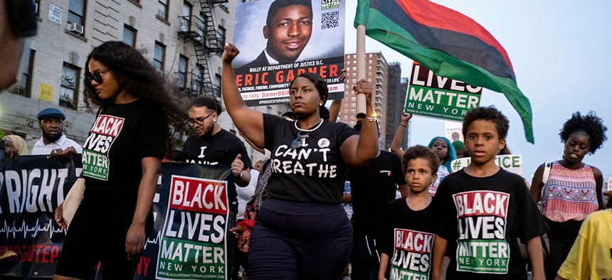 Black Lives Matter activists protest in Harlem, in the wake of a decision by federal prosecutors who declined to bring civil rights charges against NYPD officer Daniel Pantaleo. 