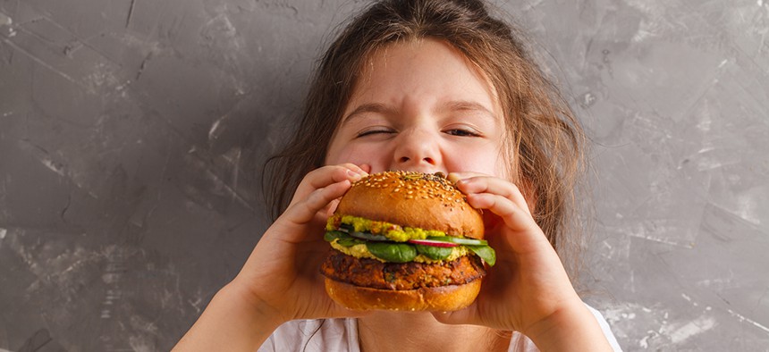 Little girl eating a veggie burger