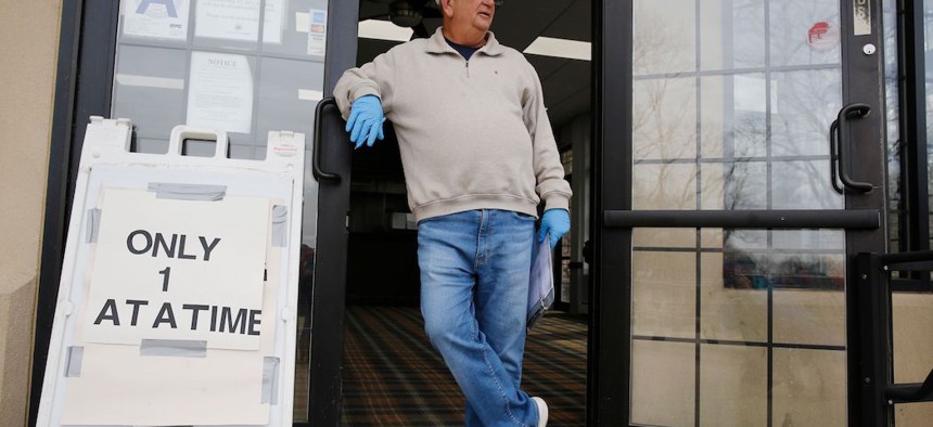 Employee Rick Lambert monitors the number of people entering the concession area at Forest Park Golf Course, in New York, while staggering tee times for golfers due to the coronavirus.