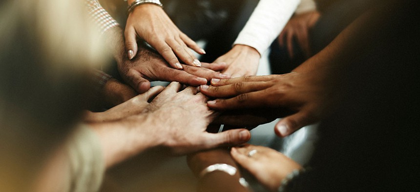 A diverse group of people joining hands.