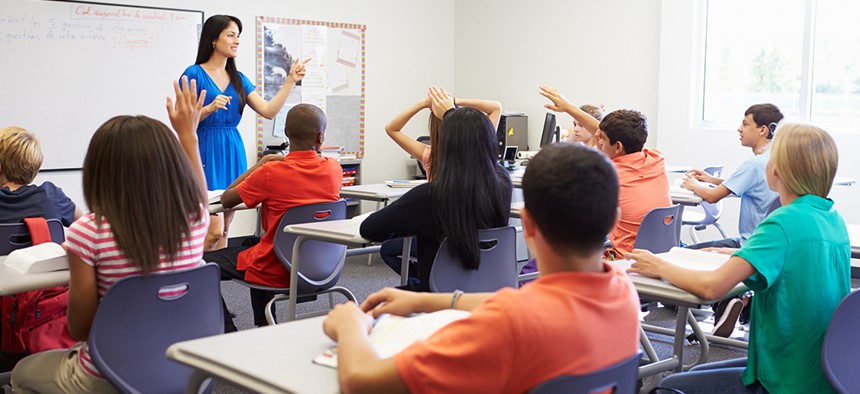Teacher addressing students in a high school classroom