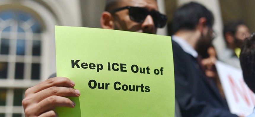 An immigration advocate holds a sign during a New York City Council rally on the steps of City Hall.