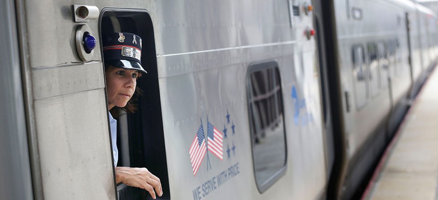 A Long Island Railroad conductor looks out of a train window.