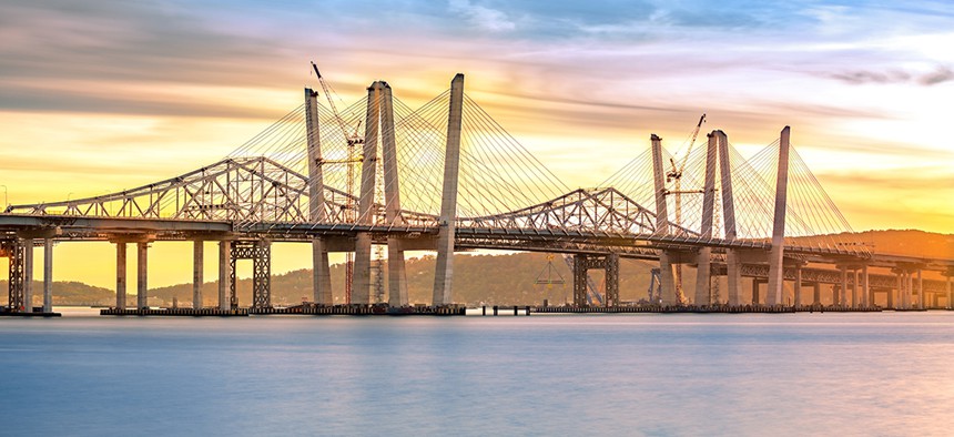 The old Tappan Zee Bridge and the new Mario Cuomo Bridge coexisting across the Hudson River at sunset. 