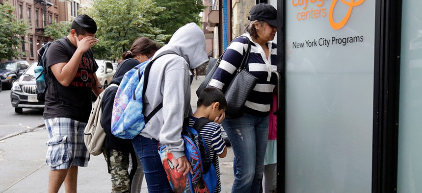 A woman and children enter the Cayuga Centers in New York City, where hundreds of migrant children separated from their parents by federal officials are being housed.