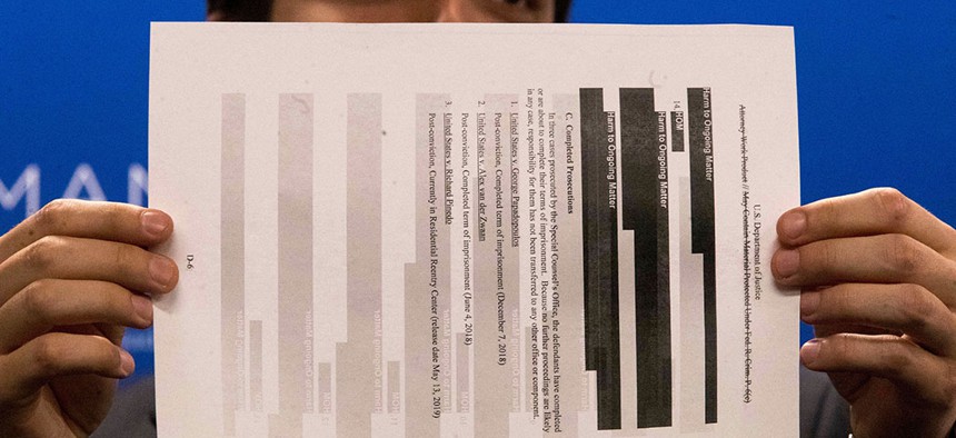 An aide to Rep. Jerrold Nadler holds a page from the redacted Robert Mueller report.