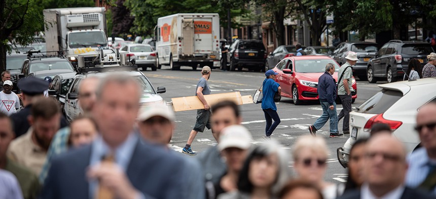 Traffic behind New York City Mayor Bill de Blasio's press conference announcing a redesign of 9th St. in Park Slope and calling for speed-camera expansion.