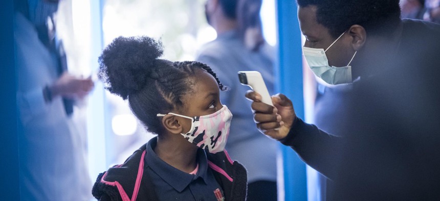 A NYC student getting her temperature checked as she walks into school on September 29th.