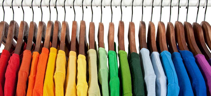 Rainbow shirts on a hanger.