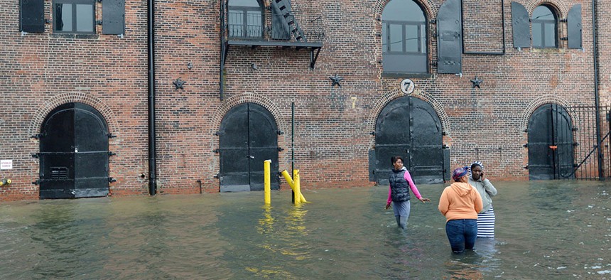 Three people making their way through a flooded street in New York City's Red Hook neighborhood during Superstorm Sandy, October 29, 2012.