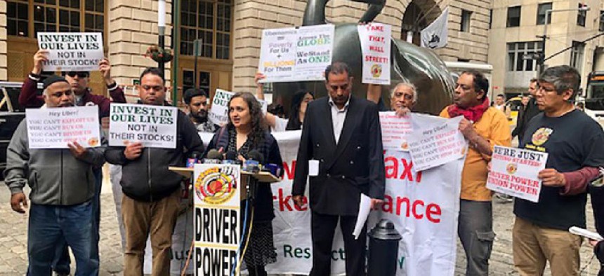 Executive director of the New York Taxi Workers Alliance Bhairavi Desai (center) speaks to reporters in New York City.