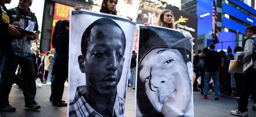 Photographs of Kalief Browder and Christopher Robinson — who both died as a result of alleged official misconduct related to Rikers Island Prison — are held up at a protest against police brutality. 