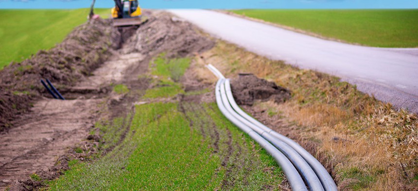Cables being embedded into the ground to provide a broadband connection in a rural area.