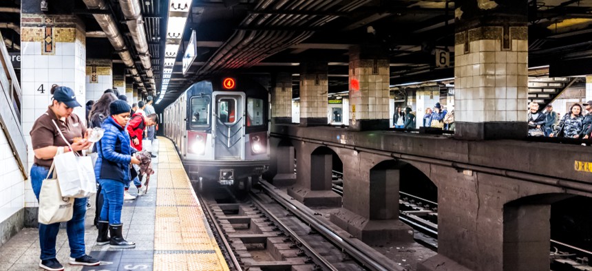 People waiting on a subway platform for the 4 train