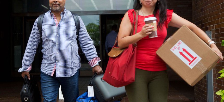 New York Daily News photo assignment editor Reggie Lewis, left, and an unidentified coworker leave the newspaper's office after they were both laid off. 