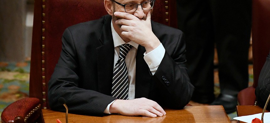SImcha Felder holds his face in the  New York Senate Chambers. 