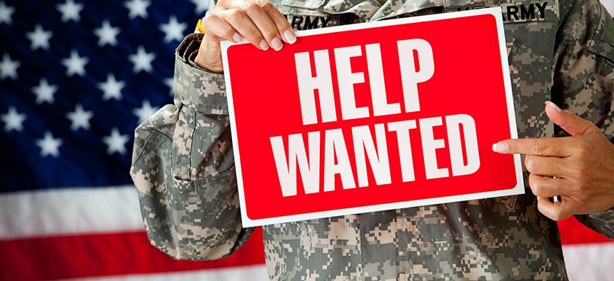 Soldier holding a help wanted sign