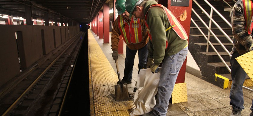 Platform tiles being replaced by MTA employees.
