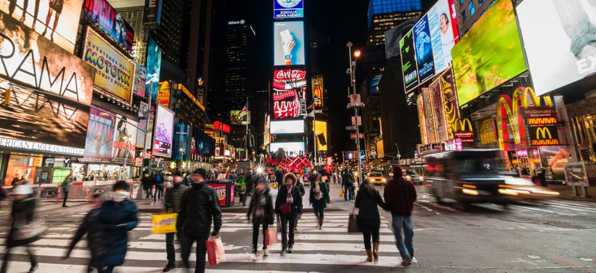 People walking in Times Square at night.