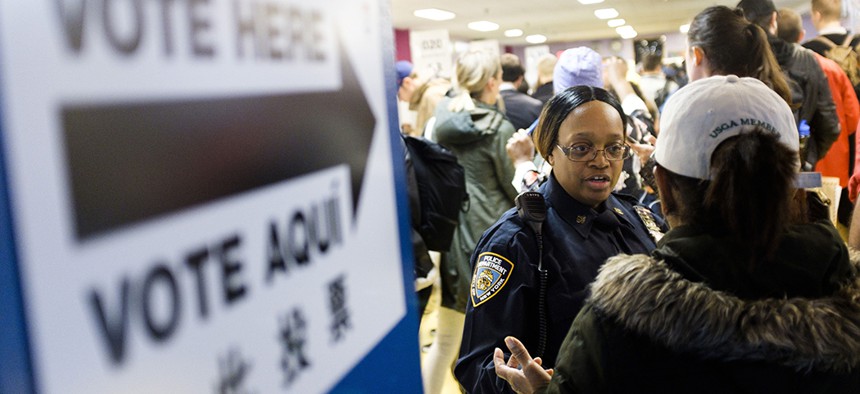 A police officers helps direct voters arriving to cast their ballots in the 2018 mid-term general election at a polling site in Brooklyn
