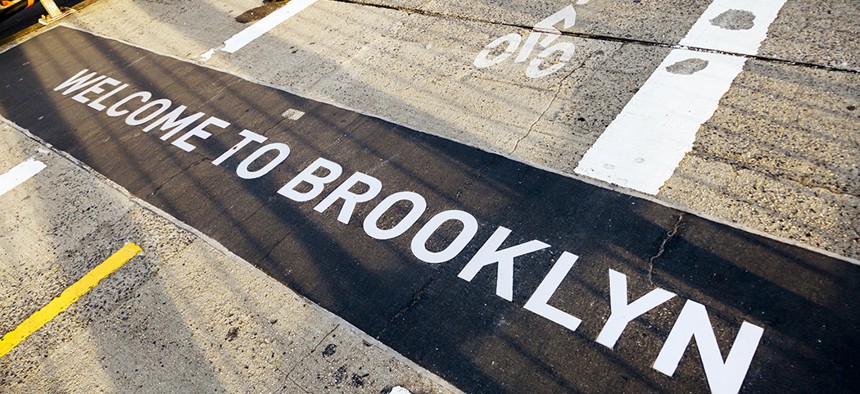 A sign on the Brooklyn Bridge denotes where Brooklyn and Manhattan meet.