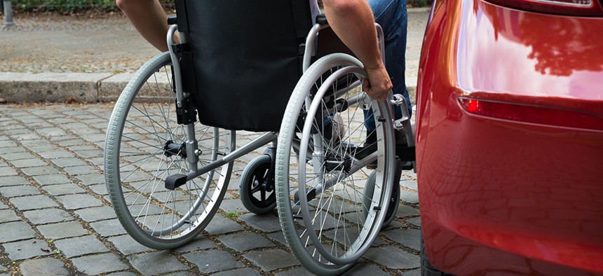 A wheelchair user getting into a car.
