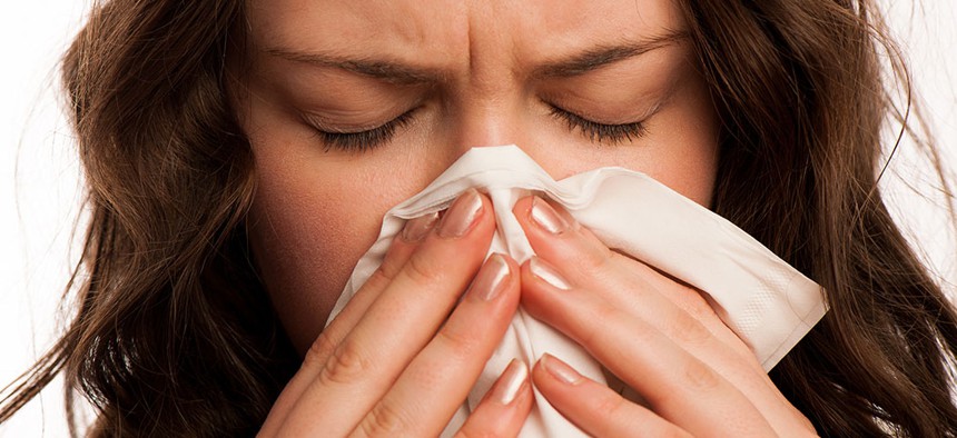 A woman blows her nose.