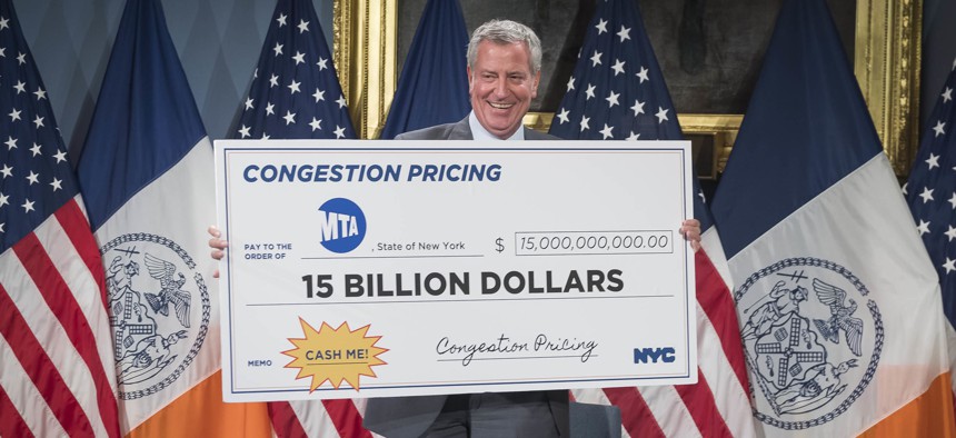 Mayor de Blasio with a check symbolizing how much revenue would come from congestion pricing.