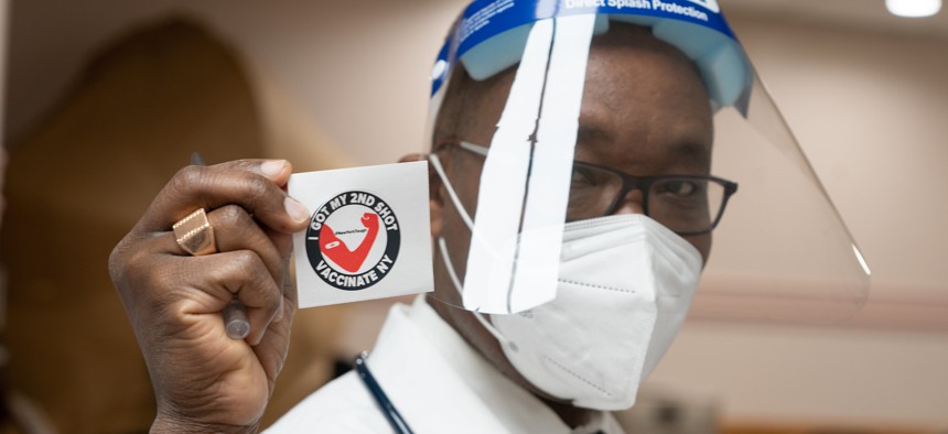 A doctor at the vaccination site at the Abyssinian Baptist Church in Harlem shows off their vaccinated sticker. 