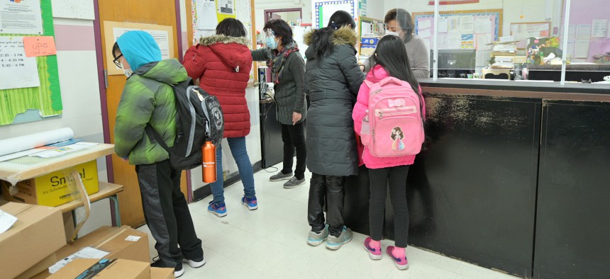 Students, parents and administrative staff gather in the main office at Yung Wing School P.S. 124 in New York City.