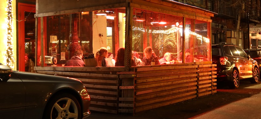 People eat dinner in an outdoor sidewalk shed at a restaurant on Bedford Street in Greenwich Village on December 17, 2021 in New York City. 