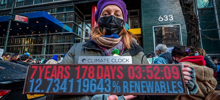 A climate protestor with a countdown clock outside the Governor's office in Jan. 2022.