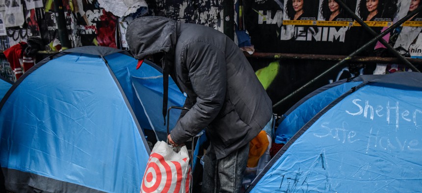 A homeless NYC resident packs up their belongings while the NYPD clear out a homeless encampment on April 6. 