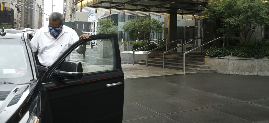 A limo driver entering his car in NYC.