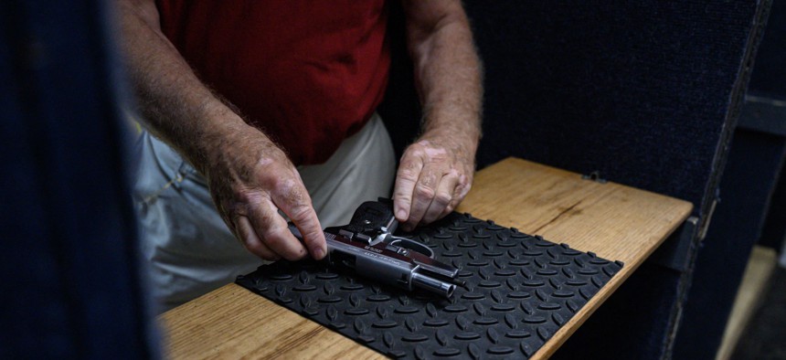A man prepares his gun at a gun range in Queens.