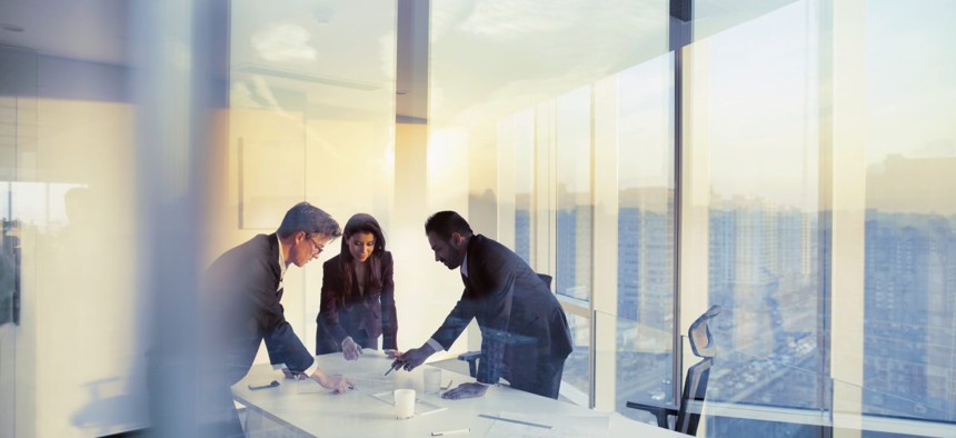 Image of three business professionals having an office meeting